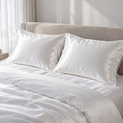 Two heavyweight 30 momme silk pillowcases styled on a queen bed